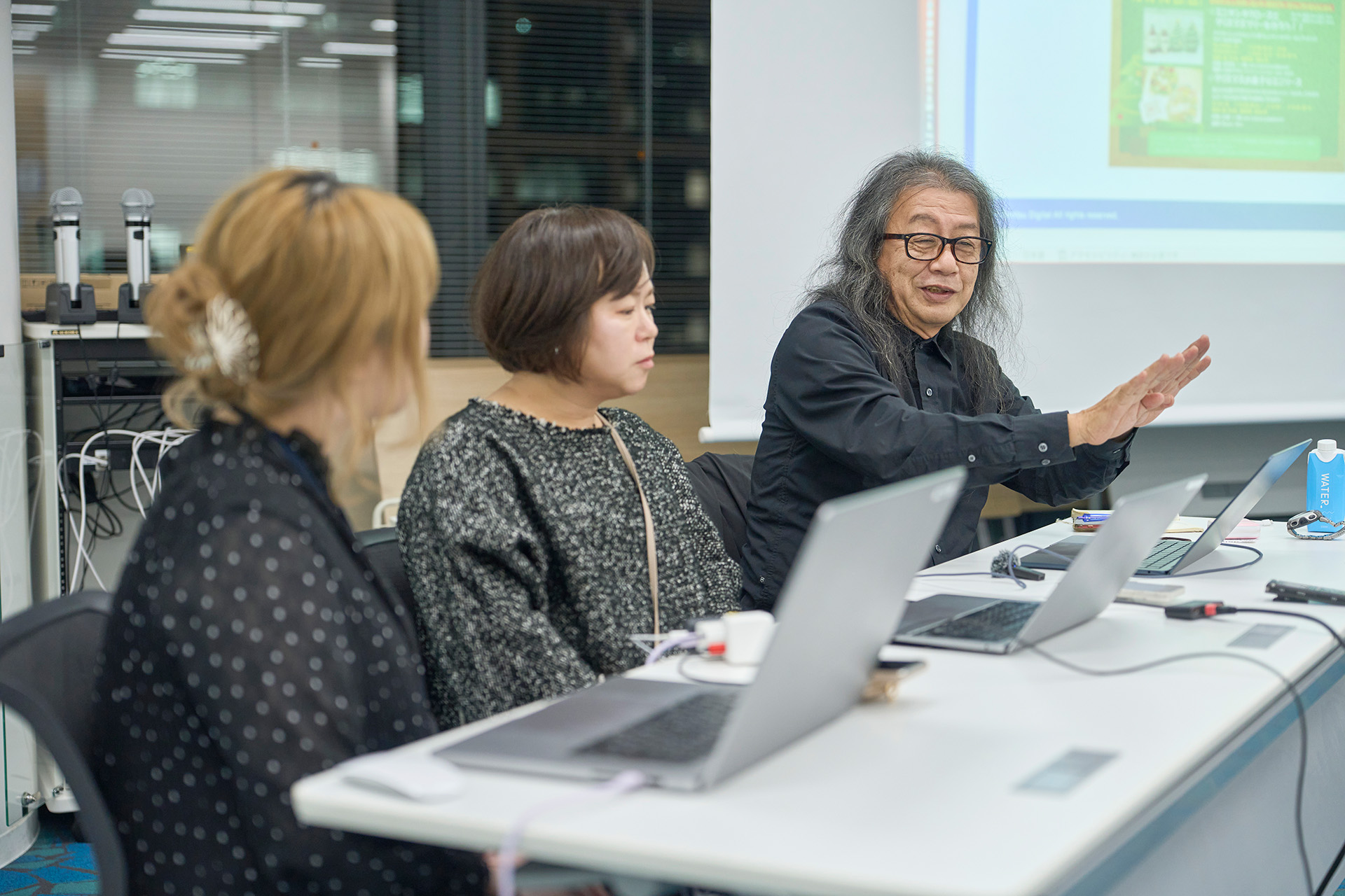 写真：色の識別について説明する伊賀氏と、それを聞く西垣戸と千葉