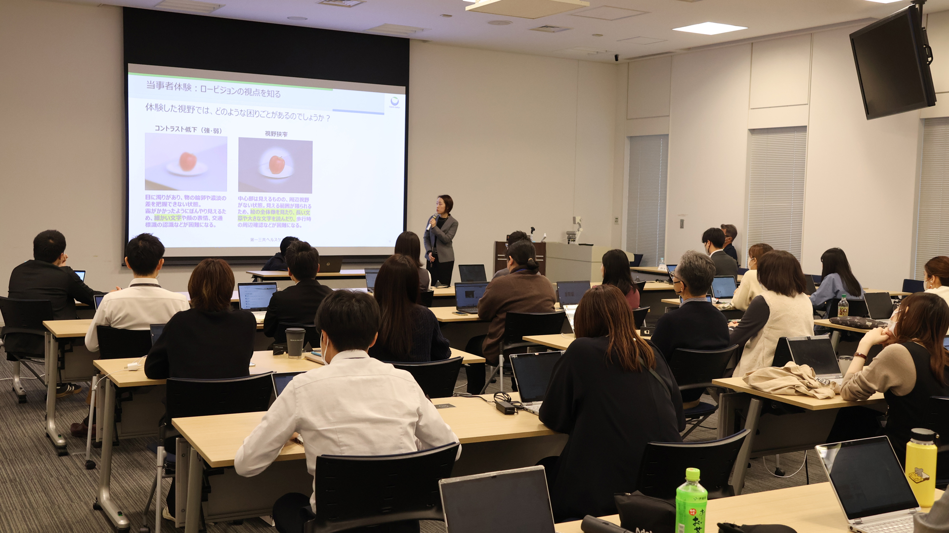 勉強会で登壇し、参加者の前でロービジョンの視点について話している加藤氏