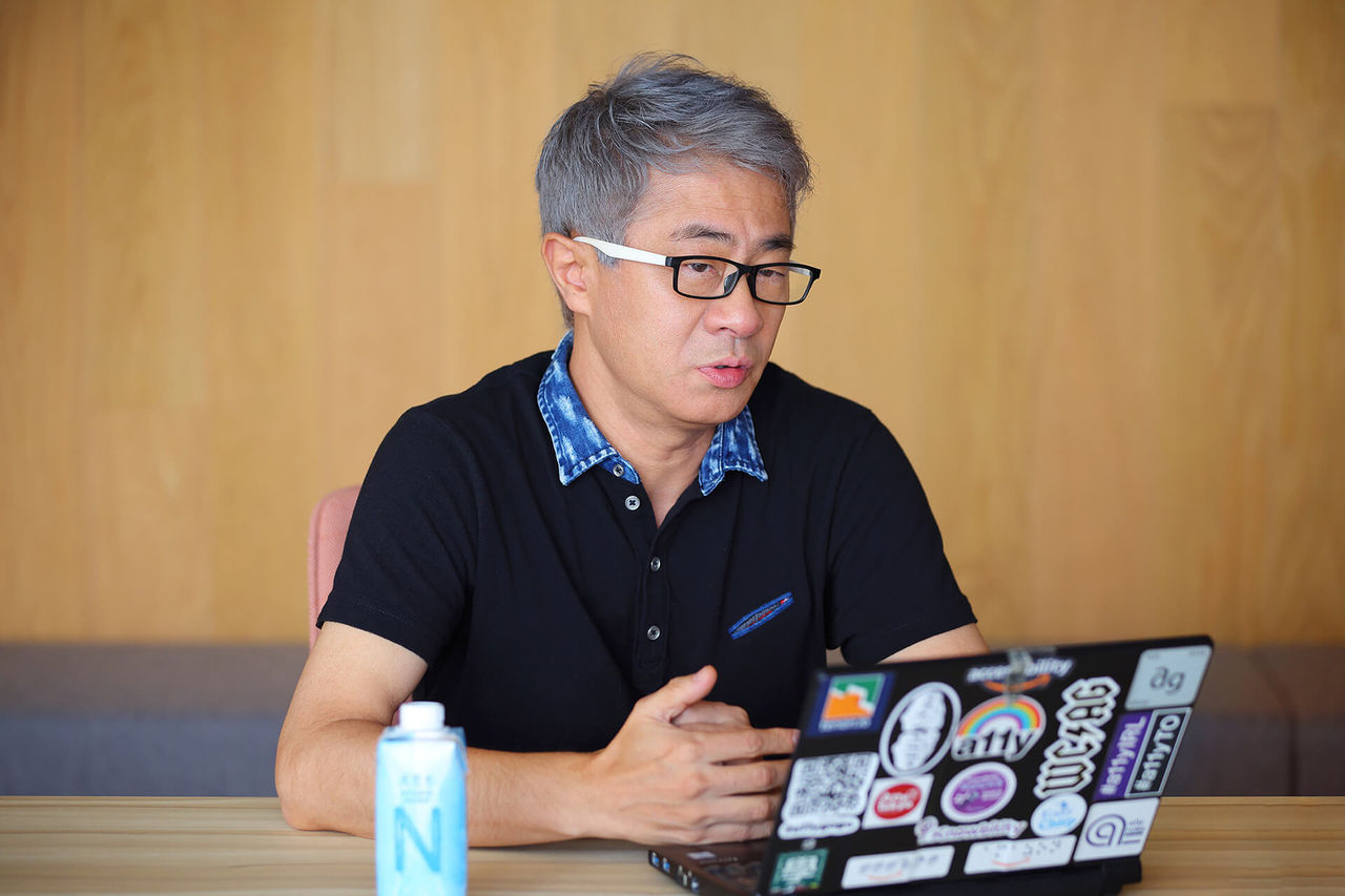 インタビュー中の写真：質問に答えている植木氏