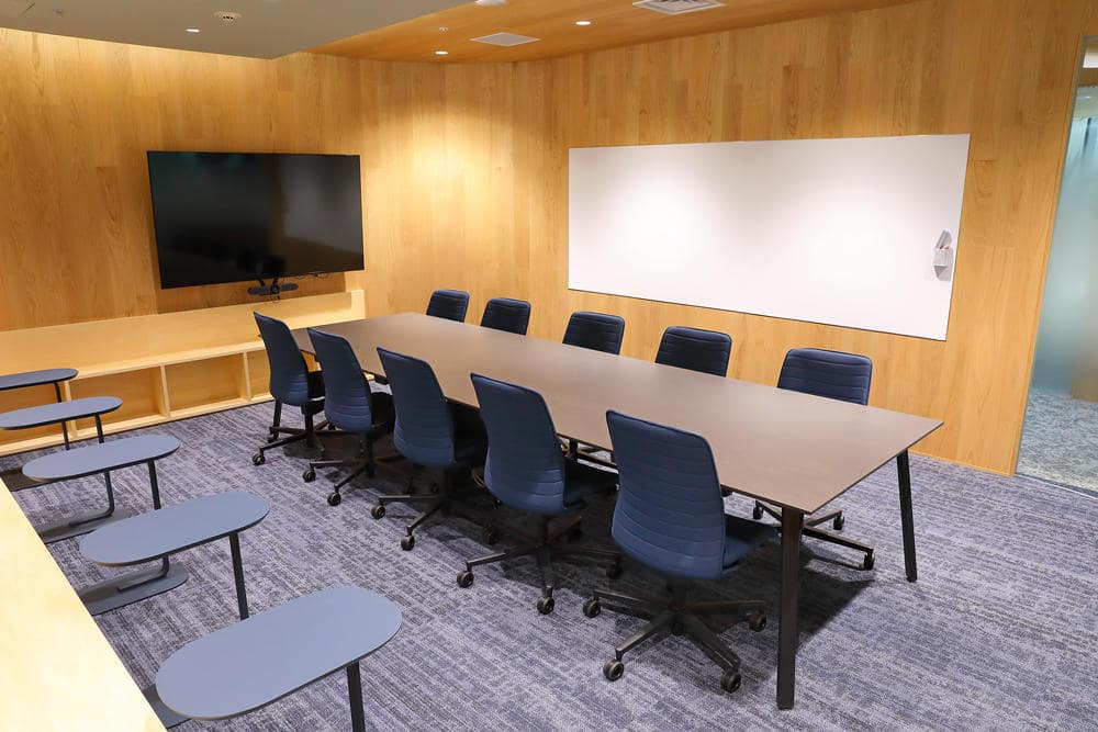 言葉の天秤の展示の様子。白を基調とした壁に設けられた3段の棚に、さまざまな言葉が書かれた白いブロックが収められている。書かれている言葉は、「Mr.」「she」「●●さん」「Ladies and Gentlemen」「（ひらがなで）きょうだい」「hen」「夫」「恋人」「Mx.」など