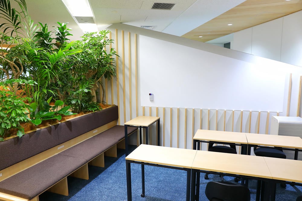 言葉の天秤の展示の様子。白を基調とした壁に設けられた3段の棚に、さまざまな言葉が書かれた白いブロックが収められている。書かれている言葉は、「Mr.」「she」「●●さん」「Ladies and Gentlemen」「（ひらがなで）きょうだい」「hen」「夫」「恋人」「Mx.」など