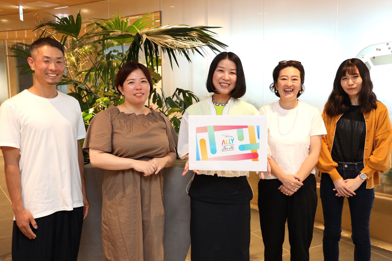 写真：「アライプロジェクト」のロゴを持つ、プロジェクトメンバーの集合写真