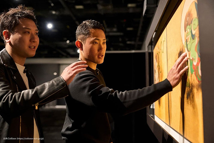 写真：「風神雷神図屏風」に触れる若生選手と、その横で解説する澤田